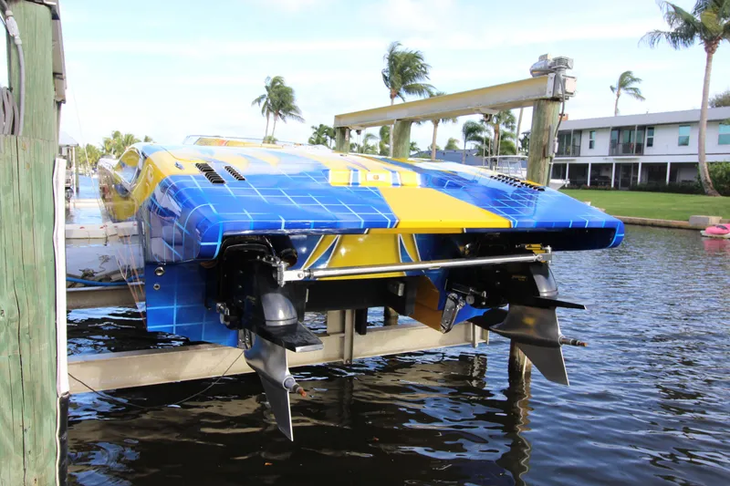 Slide: The Image of Blue and yellow MTI 40RP speedboat docked, 2007 model, with palm trees in the background. - 24