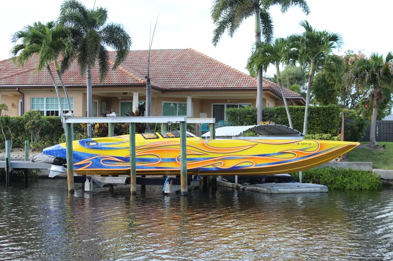 Slide: The Image of Colorful 2007 MTI 40RP speedboat docked by waterfront home with palm trees. - 25