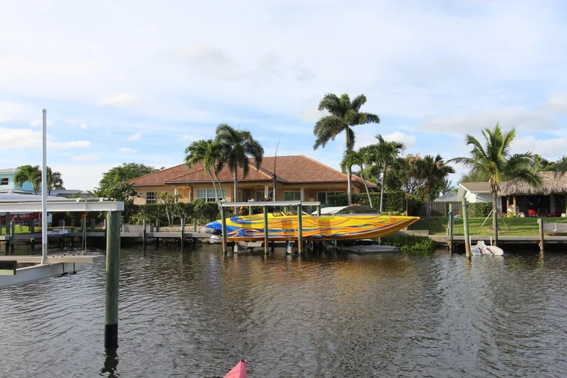 Slide: The Image of Tropical waterfront home with 2007 MTI 40RP speedboat docked, surrounded by palm trees. - 26