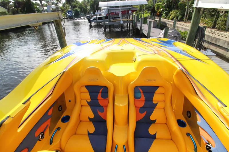 Slide: The Image of Yellow 2007 MTI 40RP speedboat with vibrant flame-patterned seats docked by the water. - 6