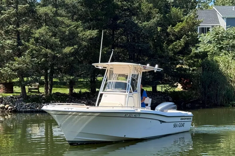 Slide: The Image of 2008 Grady-White Fisherman 222 boat on a serene lake, surrounded by lush greenery. - 0