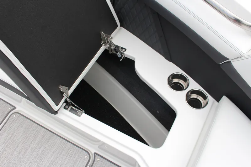 Slide: The Image of 2025 Cobalt R8 boat storage compartment with cup holders, open lid, and sleek interior design. - 20