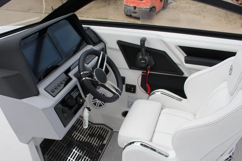 Slide: The Image of 2025 Cobalt R8 boat cockpit with modern steering, dual screens, and white leather seating. - 24