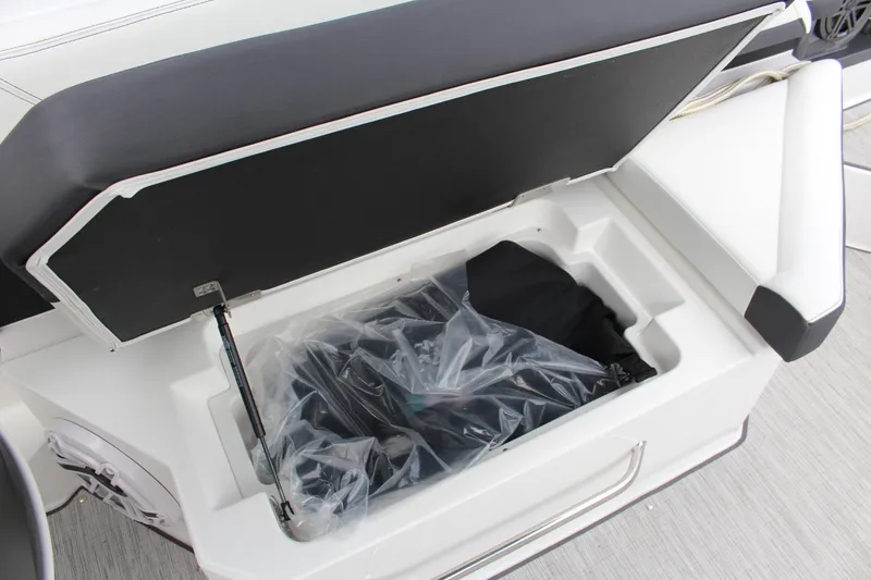 Slide: The Image of 2025 Cobalt R8 boat storage compartment with open lid, revealing interior contents. - 27