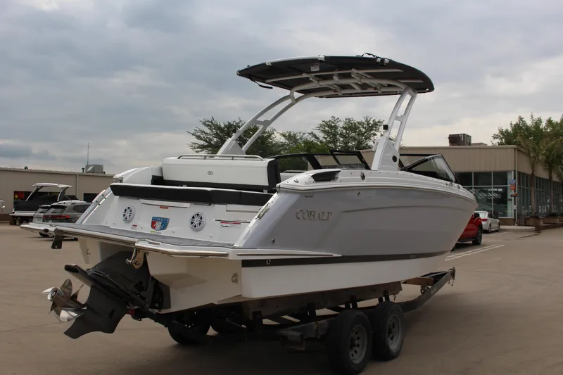 Slide: The Image of 2025 Cobalt R8 boat on trailer, parked outdoors under cloudy sky. - 6