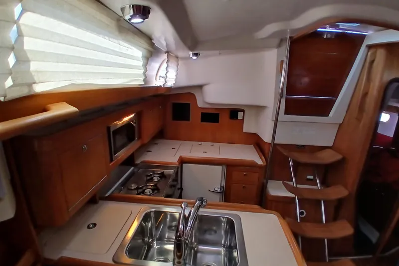 Slide: The Image of Interior of a 2003 Catalina 350 yacht featuring a compact kitchen area. - 13