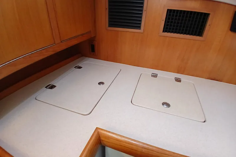 Slide: The Image of 2003 Catalina 350 yacht interior with wooden cabinetry and countertop storage. - 14