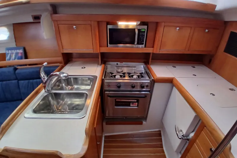 Slide: The Image of 2003 Catalina 350 yacht kitchen with stove, microwave, and double sink. - 17