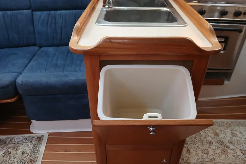 Slide: The Image of Interior of 2003 Catalina 350 yacht with sink, blue seating, and wooden cabinetry. - 18