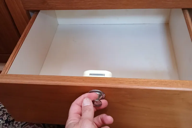 Slide: The Image of Open wooden drawer with hand holding handle, revealing empty interior. Catalina 350, 2003. - 23