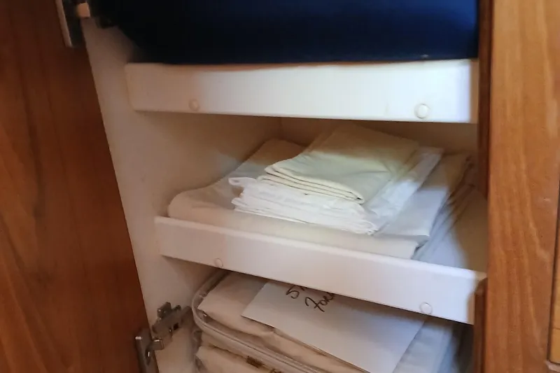 Slide: The Image of Storage shelves with neatly folded linens inside a 2003 Catalina 350 boat. - 26