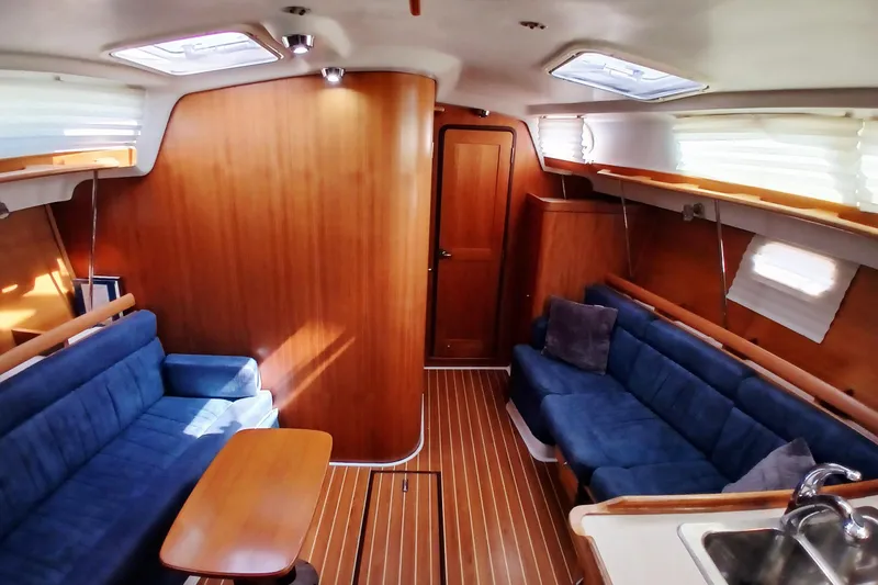 Slide: The Image of Interior of 2003 Catalina 350 sailboat with blue seating and wooden finishes. - 4
