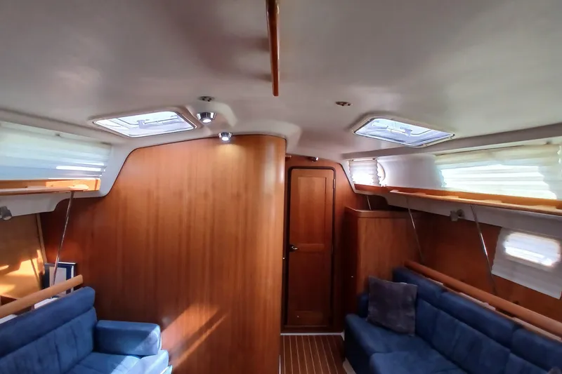Slide: The Image of Interior of a 2003 Catalina 350 sailboat with wood paneling and blue seating. - 5