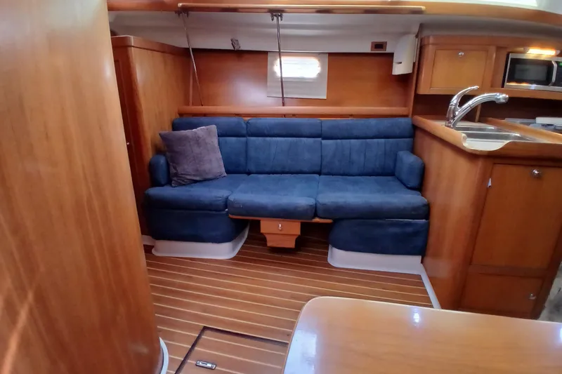 Slide: The Image of Interior of 2003 Catalina 350 sailboat with blue sofa and wooden cabinetry. - 7