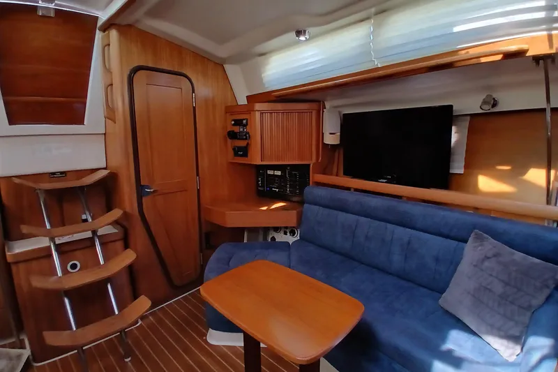 Slide: The Image of Interior of a 2003 Catalina 350 sailboat with blue seating and wooden accents. - 8