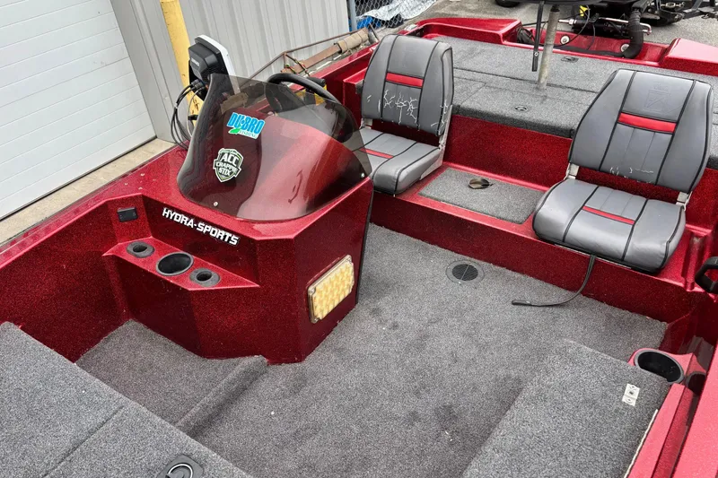 Slide: The Image of 1995 Hydra-Sports Z260 boat interior with red and gray seating, steering console, and carpeted floor. - 4