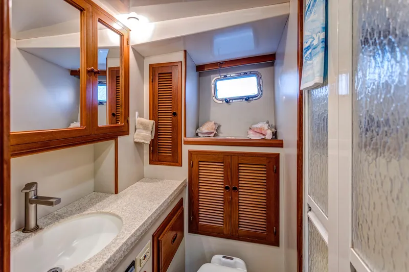 Slide: The Image of Luxurious bathroom in 2007 Krogen 44' Widebody yacht with wooden cabinetry and modern fixtures. - 11