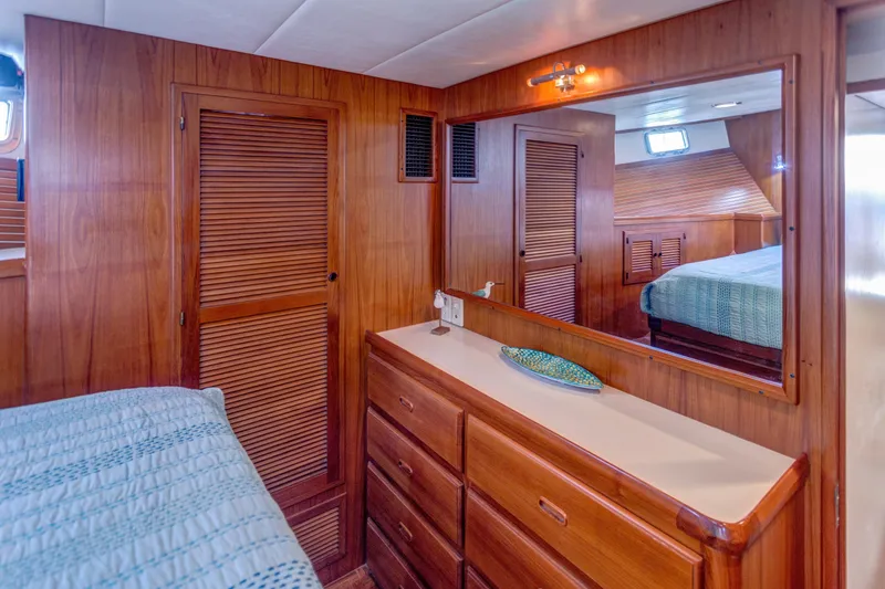 Slide: The Image of Luxurious 2007 Krogen 44' Widebody yacht interior with wooden cabinetry and cozy bedroom. - 16