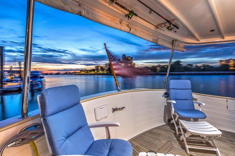 Slide: The Image of Luxurious 2007 Krogen 44' Widebody yacht deck with blue chairs at sunset. - 2