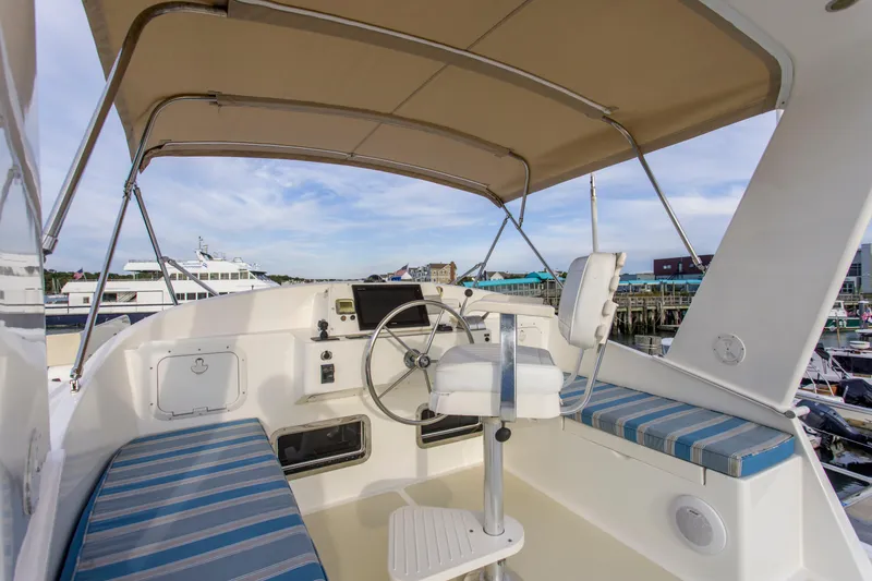 Slide: The Image of 2007 Krogen 44' Widebody yacht helm with seating and canopy in marina. - 24