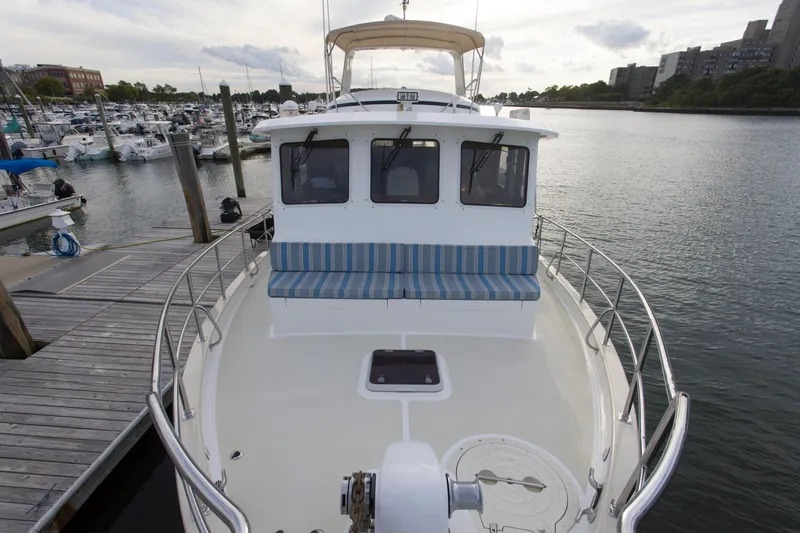 Slide: The Image of 2007 Krogen 44' Widebody yacht docked at marina, featuring spacious deck and seating. - 29