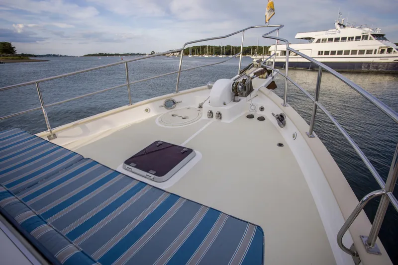 Slide: The Image of 2007 Krogen 44' Widebody yacht deck with striped seating, docked near other boats. - 30