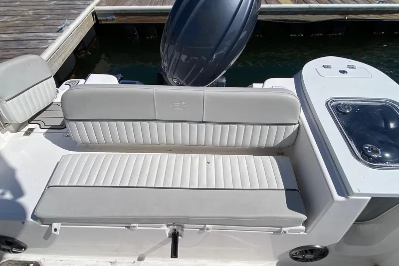 Slide: The Image of 2024 Sea Fox 228 Commander boat with cushioned seating and outboard motor at dock. - 16