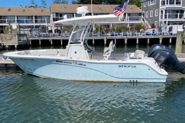 Slide: The Image of 2024 Sea Fox 228 Commander boat docked, featuring sleek design and American flag. - 20