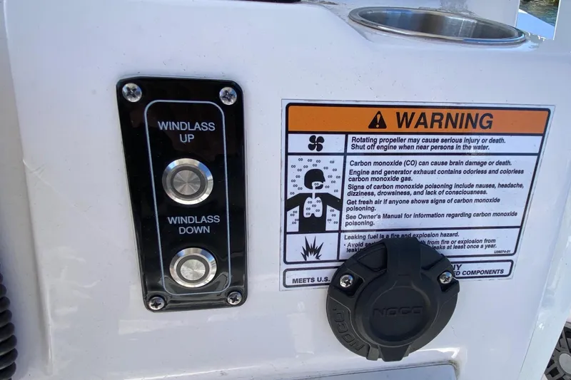 Slide: The Image of 2024 Sea Fox 228 Commander windlass controls and safety warning label. - 10