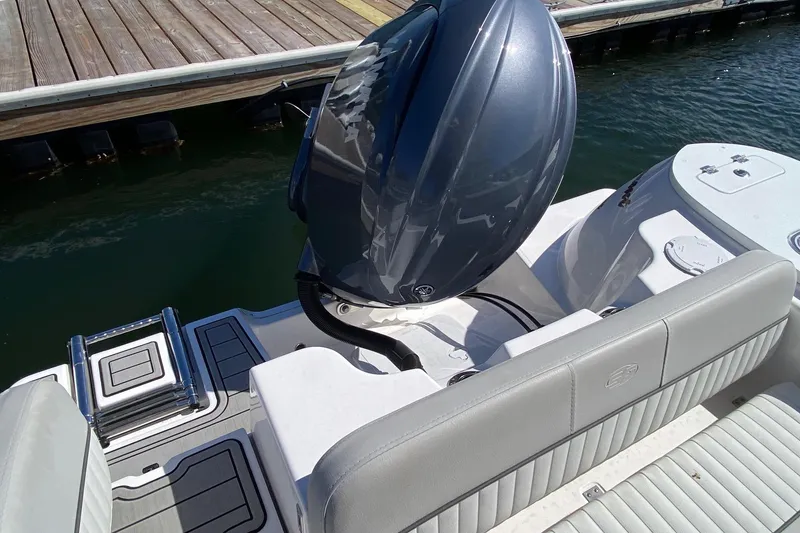 Slide: The Image of 2024 Sea Fox 228 Commander boat with outboard motor and seating, docked by wooden pier. - 18