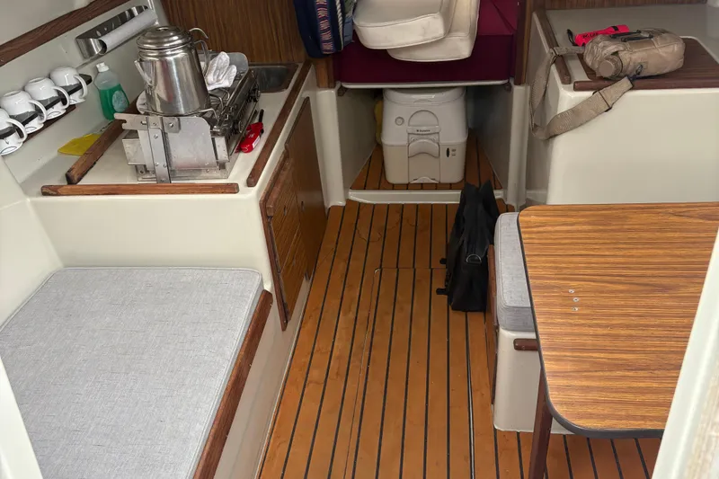 Slide: The Image of Interior of a 1983 Sonic 23 boat with kitchenette and seating area. - 14