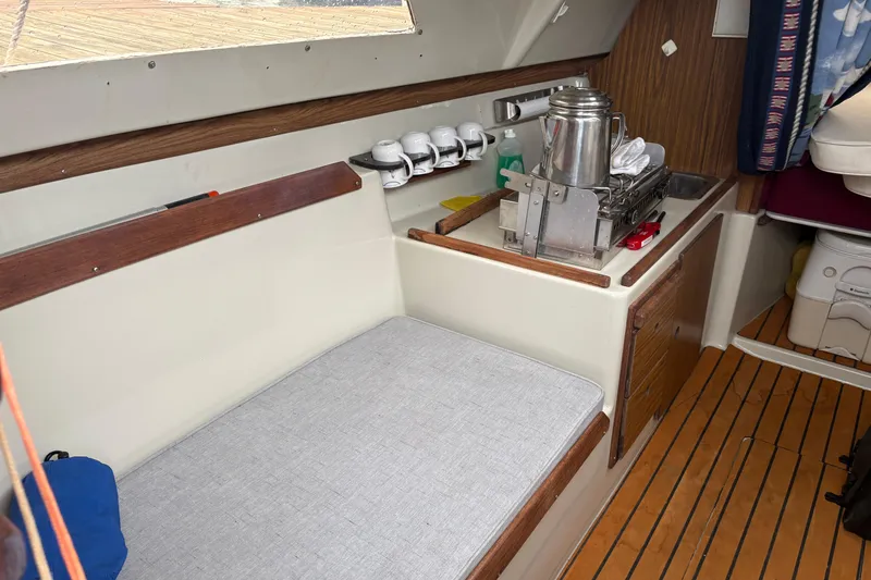 Slide: The Image of Interior of a 1983 Sonic 23 sailboat with kitchenette and seating area. - 16