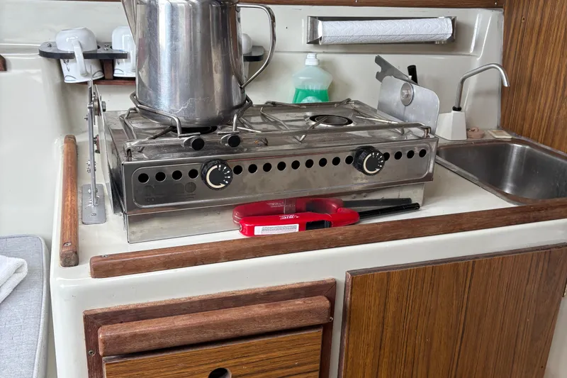 Slide: The Image of Compact kitchen area in a 1983 Sonic 23 boat with stove and sink. - 21