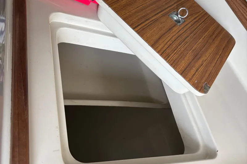 Slide: The Image of Open storage compartment on 1983 Sonic 23 boat with wooden lid. - 26