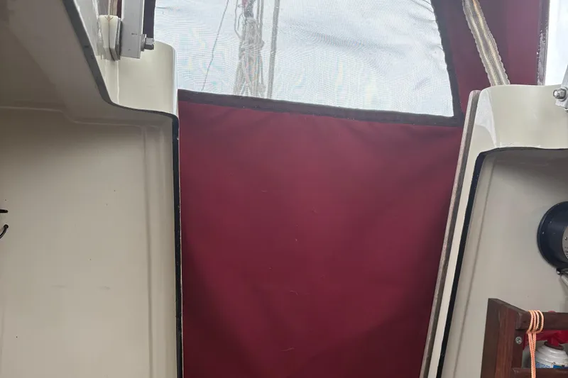 Slide: The Image of Interior view of a 1983 Sonic 23 sailboat with red canvas and white trim. - 28