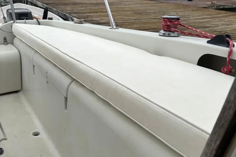 Slide: The Image of White cushioned seating on a 1983 Sonic 23 boat, dockside view. - 30