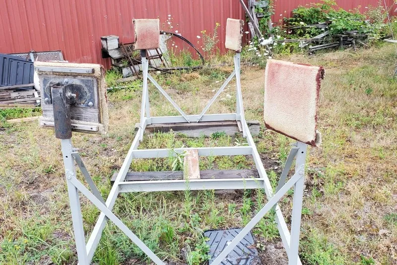 Slide: The Image of Old Sonic 23 boat trailer frame, 1983, in grassy yard with red barn background. - 31