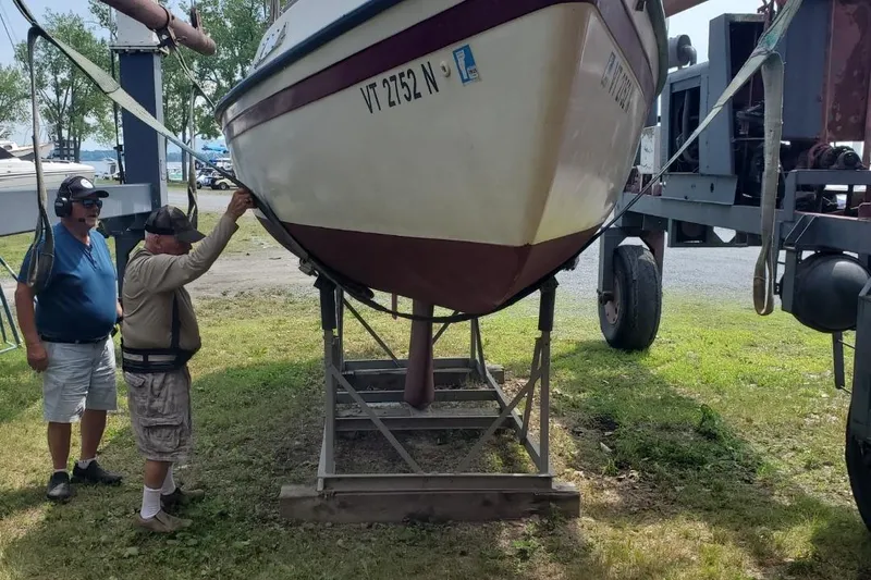 Slide: The Image of Two men inspecting a 1983 Sonic 23 boat on a trailer. - 32