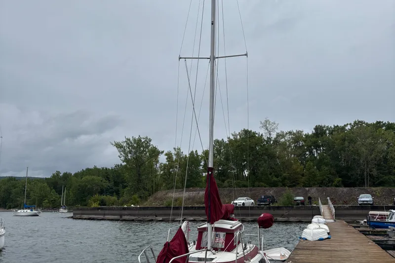 Slide: The Image of Sonic 23 sailboat from 1983 docked at a marina with overcast skies. - 5