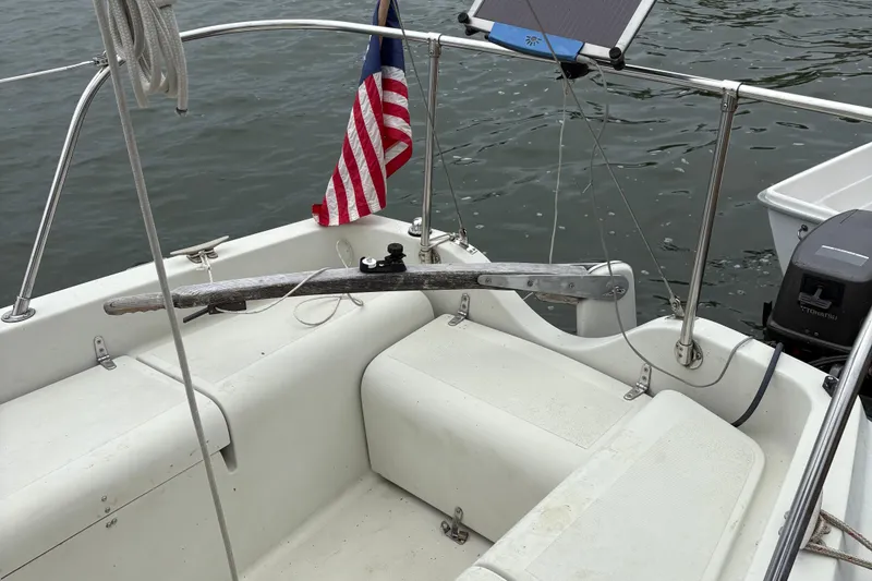 Slide: The Image of 1983 Sonic 23 sailboat cockpit with American flag and Tohatsu outboard motor. - 8