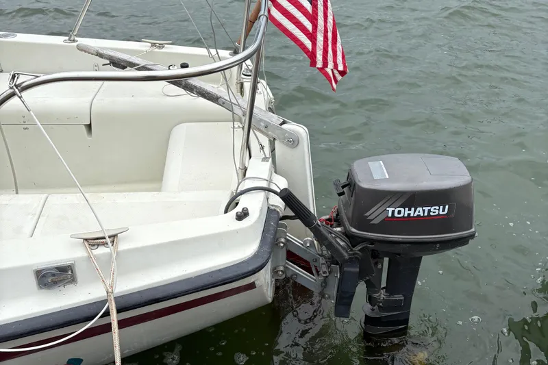 Slide: The Image of 1983 Sonic 23 boat with Tohatsu outboard motor and American flag on water. - 9