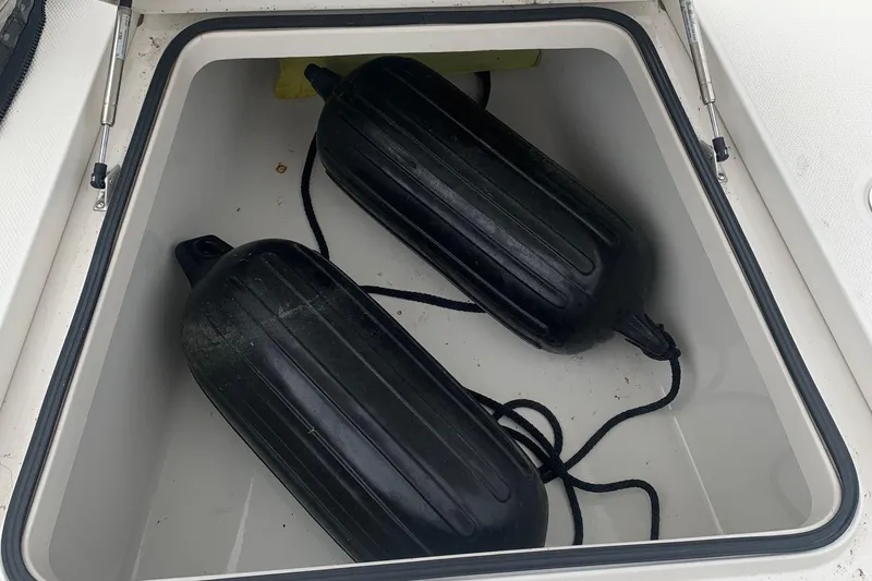 Slide: The Image of Open storage compartment with black boat fenders in a 2016 Ranger 2510 Bay Ranger. - 13