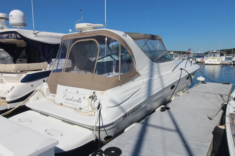 The Image of 2004 Larson 370 Cabrio boat docked at marina under clear blue sky. - 1