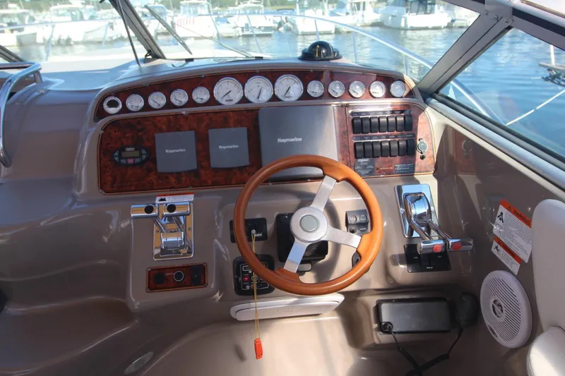 Slide: The Image of Cockpit of 2004 Larson 370 Cabrio boat with steering wheel and control panel. - 16