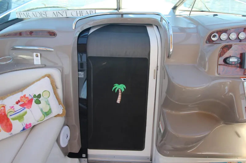 Slide: The Image of 2004 Larson 370 Cabrio boat interior with tropical decor and "Paradise Ain't Cheap" sign. - 17