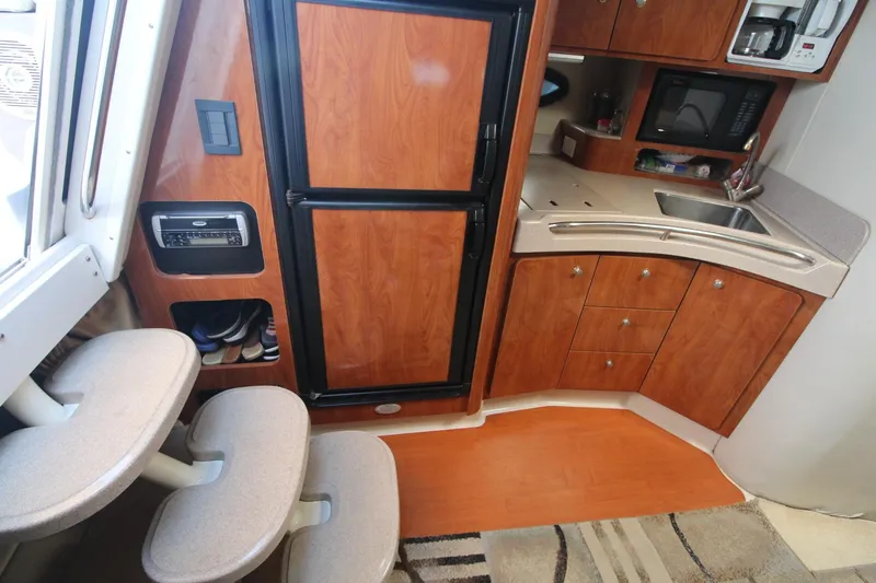 Slide: The Image of Interior of 2004 Larson 370 Cabrio boat with kitchenette and wooden cabinetry. - 24