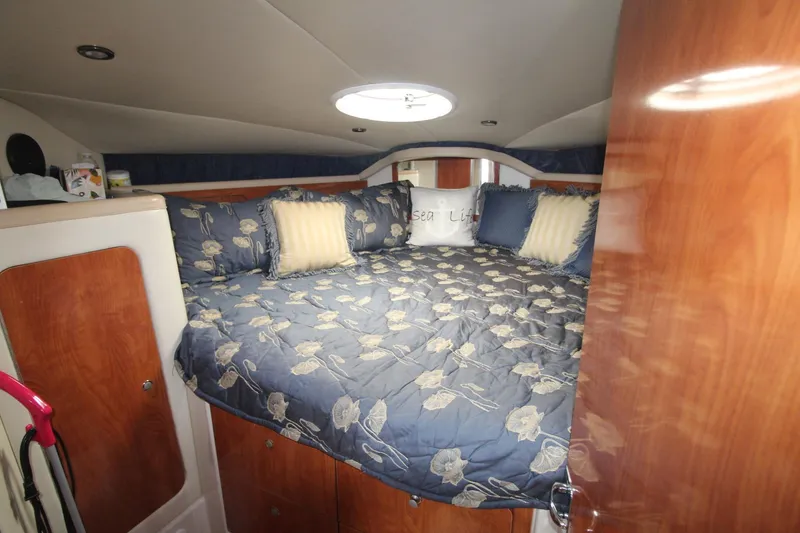 Slide: The Image of Cozy cabin interior of 2004 Larson 370 Cabrio with floral bedding and wood accents. - 27
