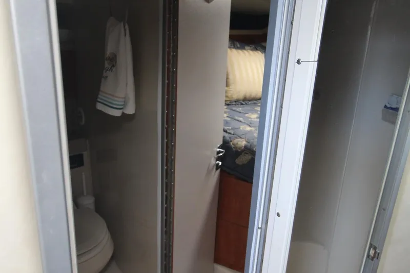 Slide: The Image of Interior of 2004 Larson 370 CABRIO showing bathroom and bedroom with blue bedding. - 34