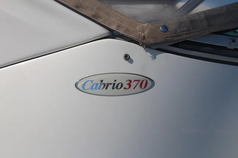 Slide: The Image of 2004 Larson 370 Cabrio boat emblem on white surface. - 4