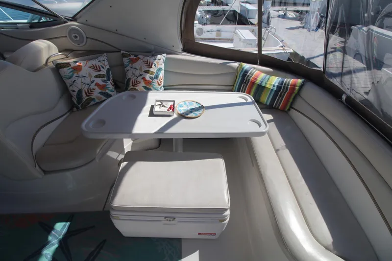 Slide: The Image of 2004 Larson 370 Cabrio boat interior with table, cushions, and seating area. - 8